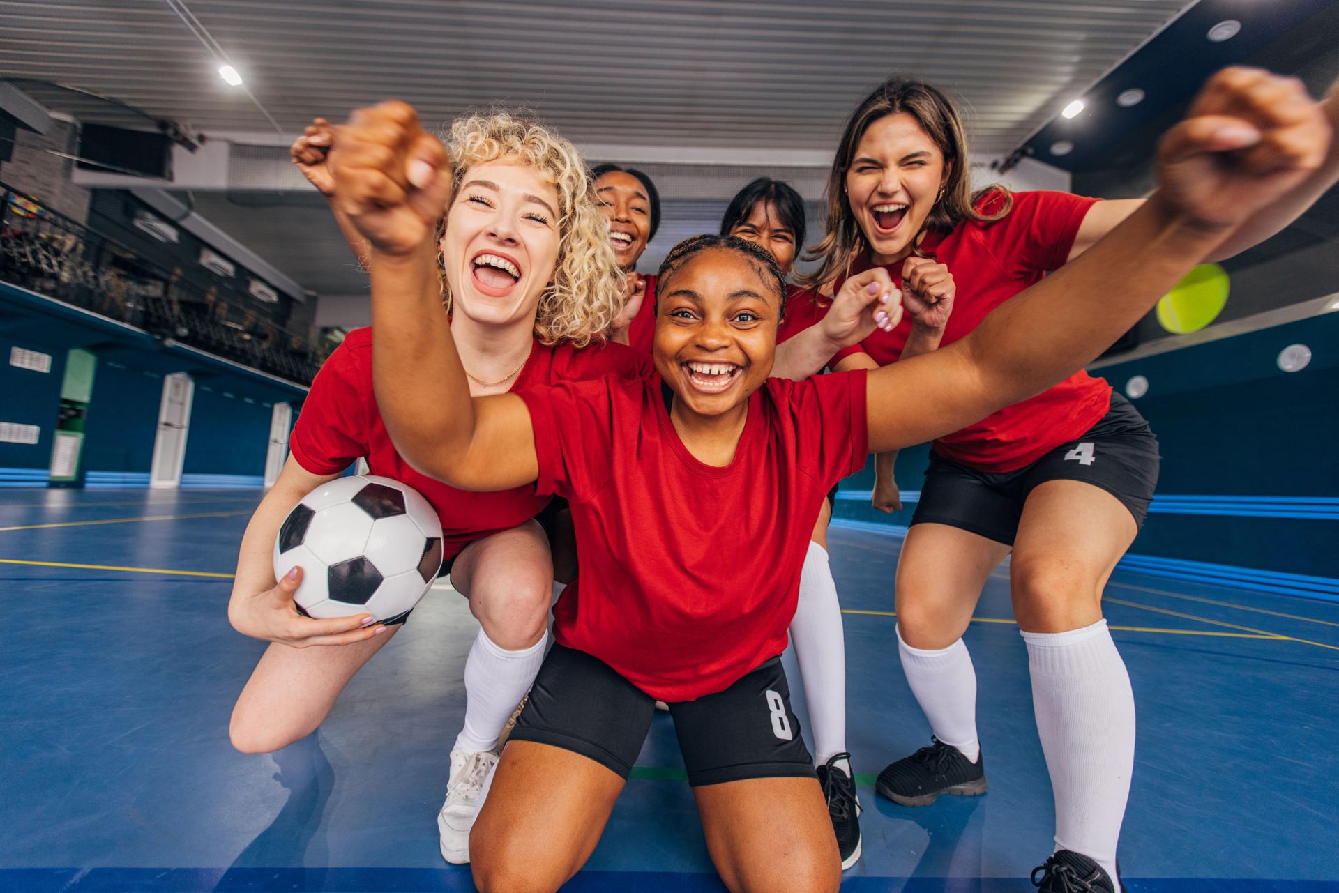 Excited women on blue court celebrating triumph together