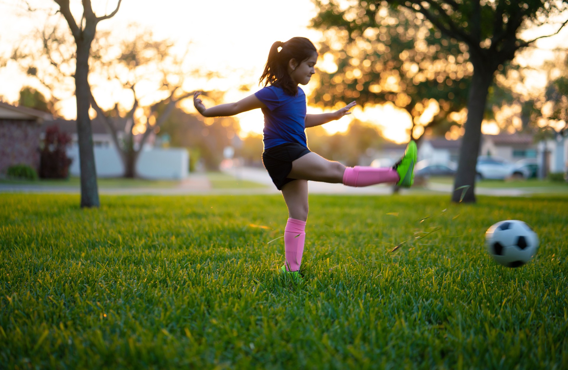 Girl kicking a soccer ball in the park