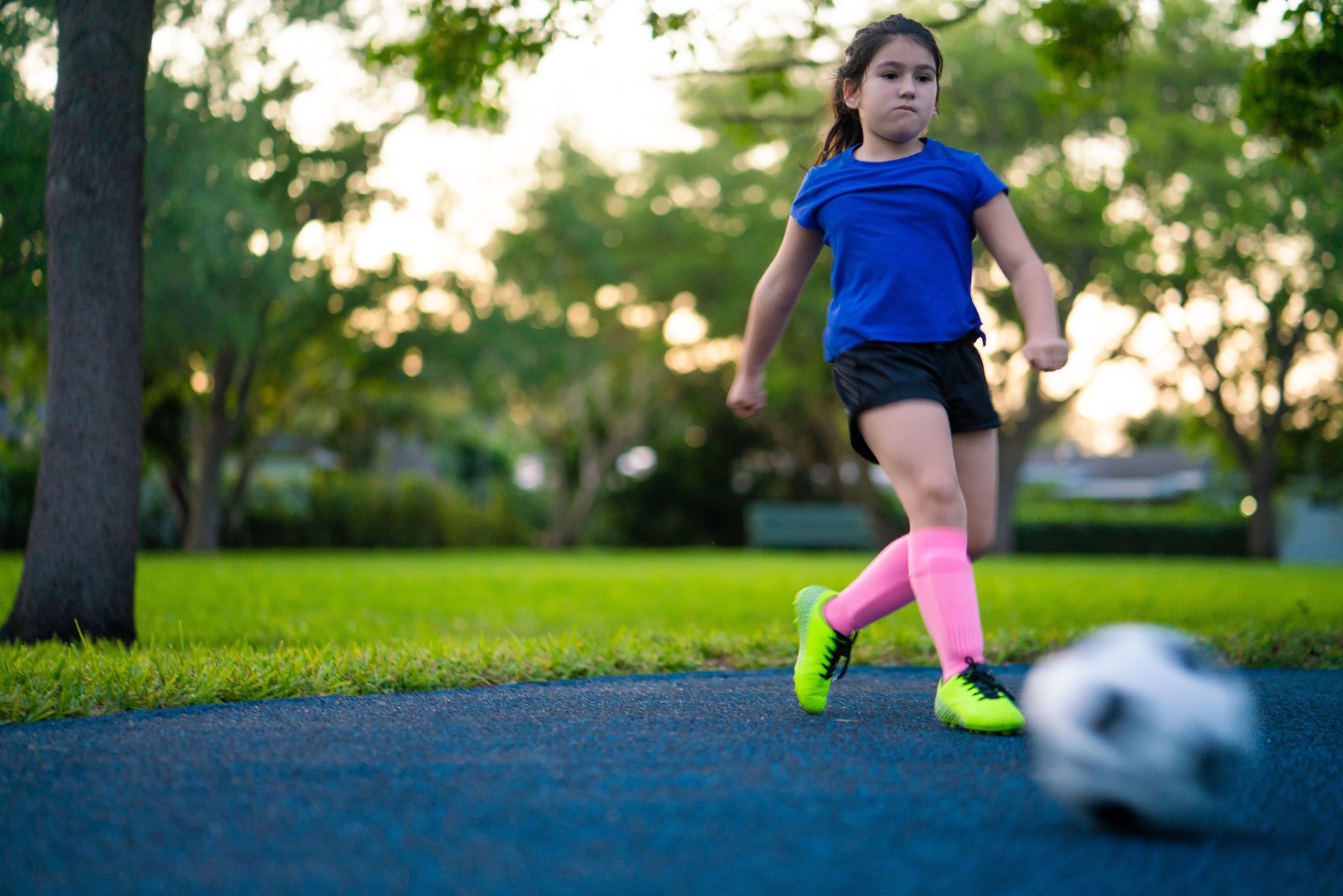 Girl kicking a soccer ball in the park