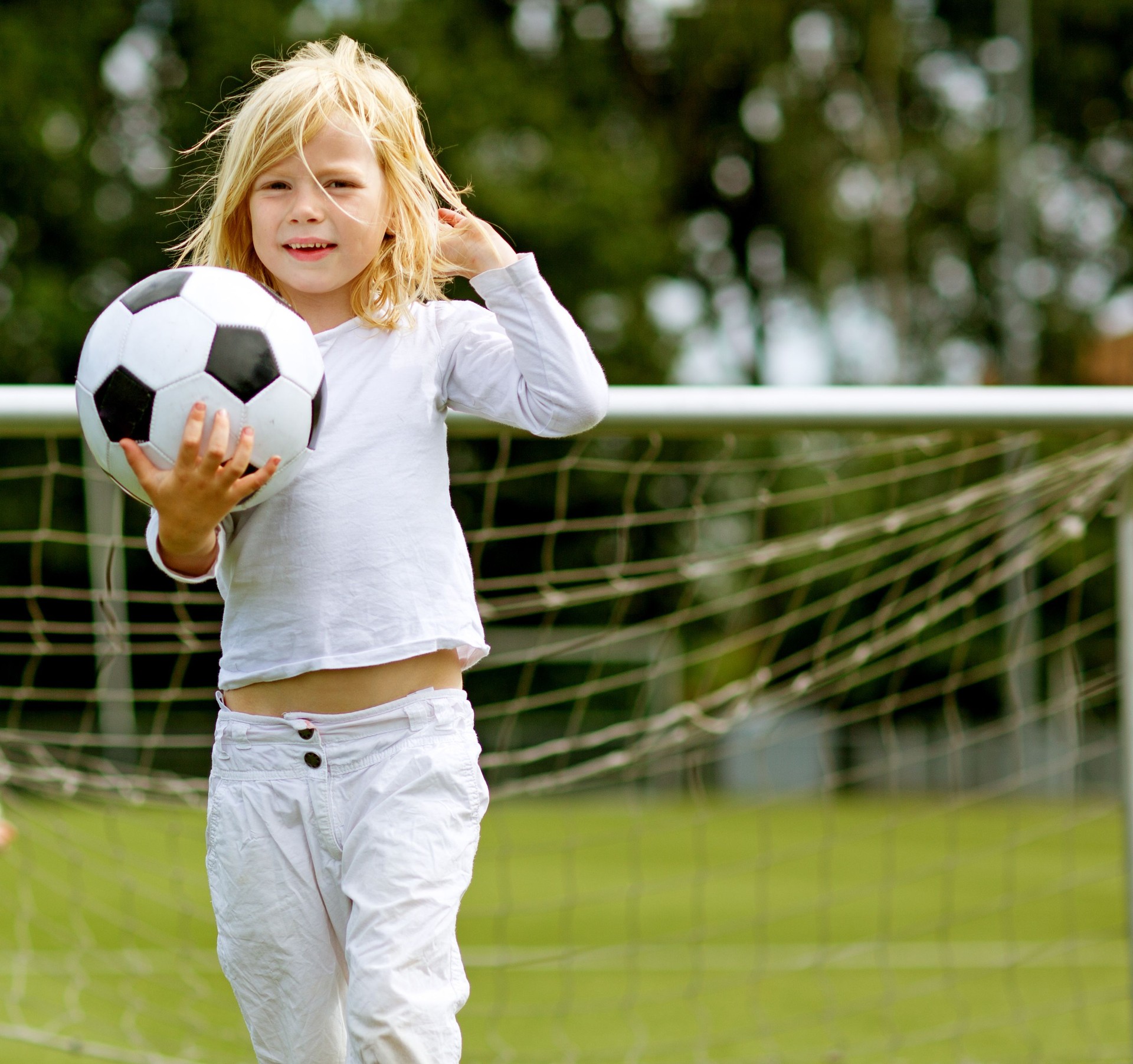 Young blonde girl holding a football